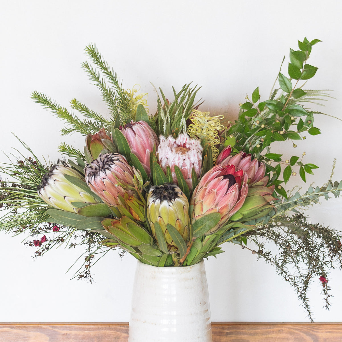 Closeup of a protea arrangement, sustainable protea bouquet, pink, yellow, white and green protea flowers