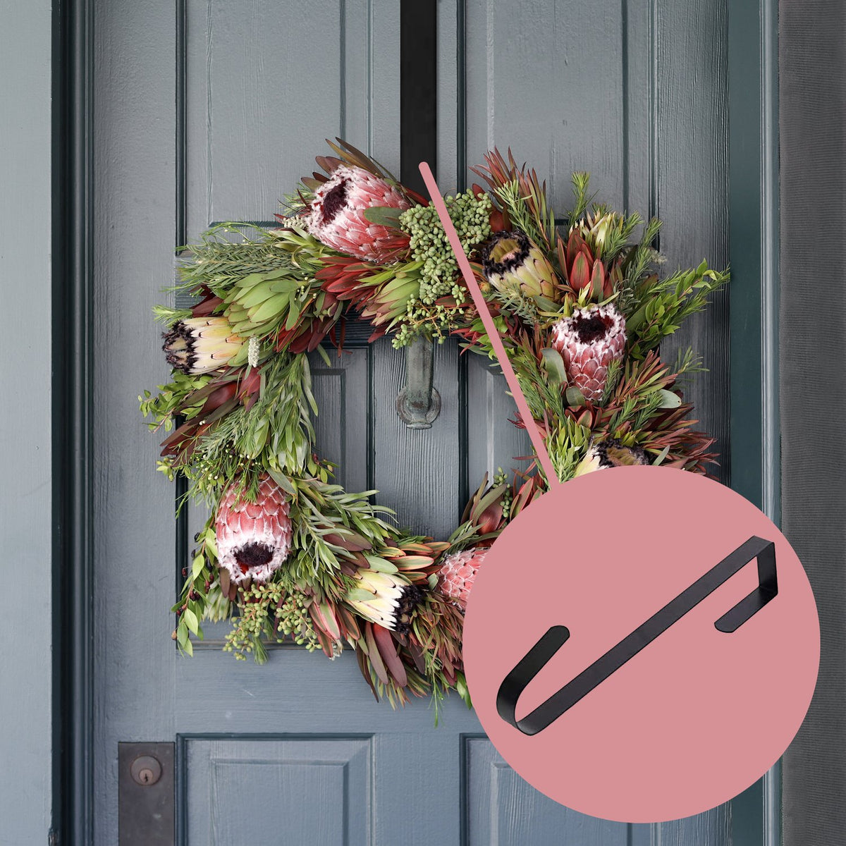 Holiday protea wreath hanging on a door with a wreath hanger